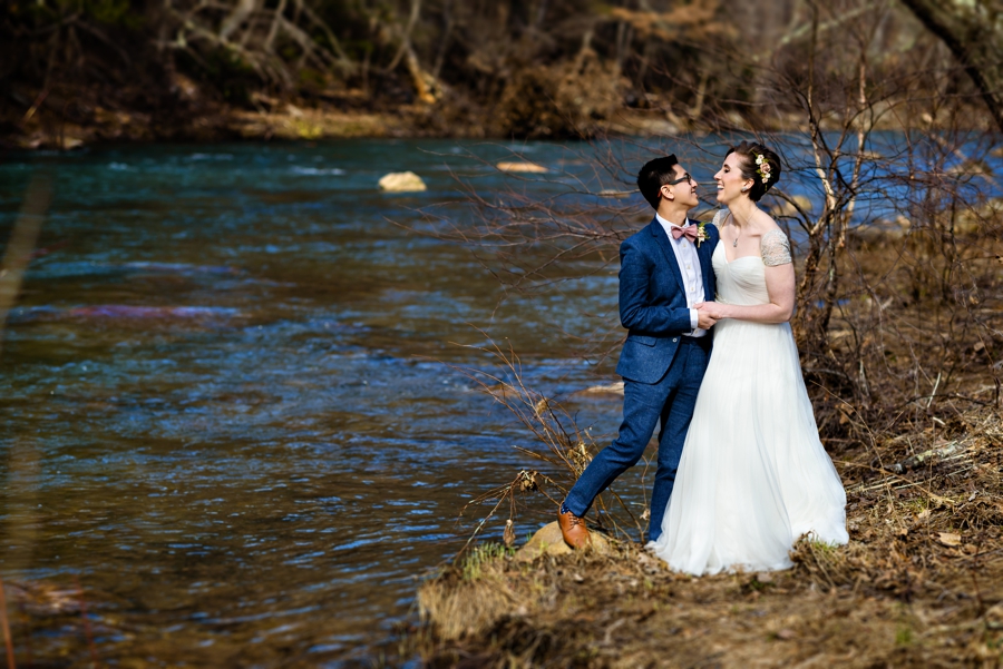 A newly married couple kiss along the Catawissa Creek at their Pump House B&B Wedding.