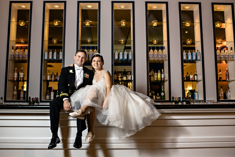 A newly married couple sit on the bar at their reception at Vie in Philadelphia.