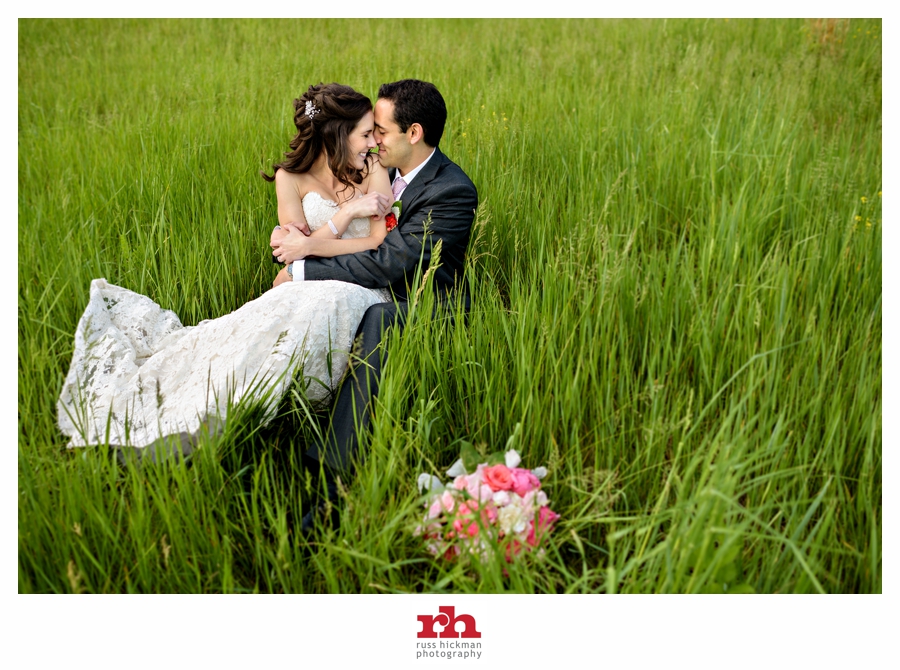 A Bride and Groom lay in the grass and kiss after their Holly Hedge Estate Wedding.