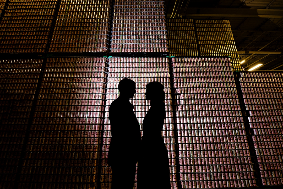 A silhouette of a bride and groom in front of beer cans at Yards Brewing Company.
