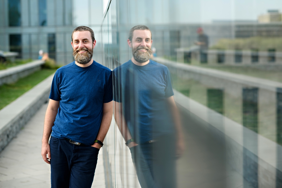 A company headshot of a man with his reflection.