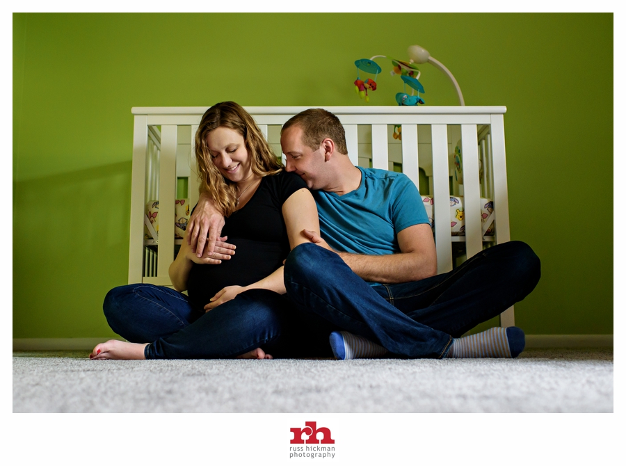 New parents sit in front of their baby's crib at their Maternity Session.