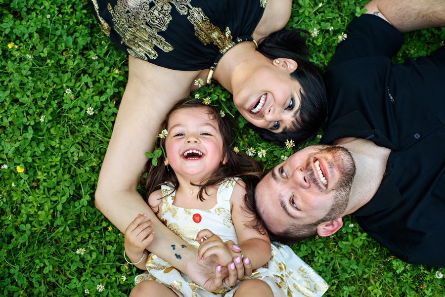 A family lay in the grass and laugh during their Philadelphia Family Photography Session.