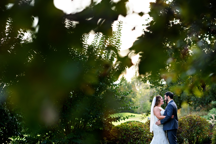 A bride and groom kiss under the fall leaves at The Manor House at Commonwealth Wedding.