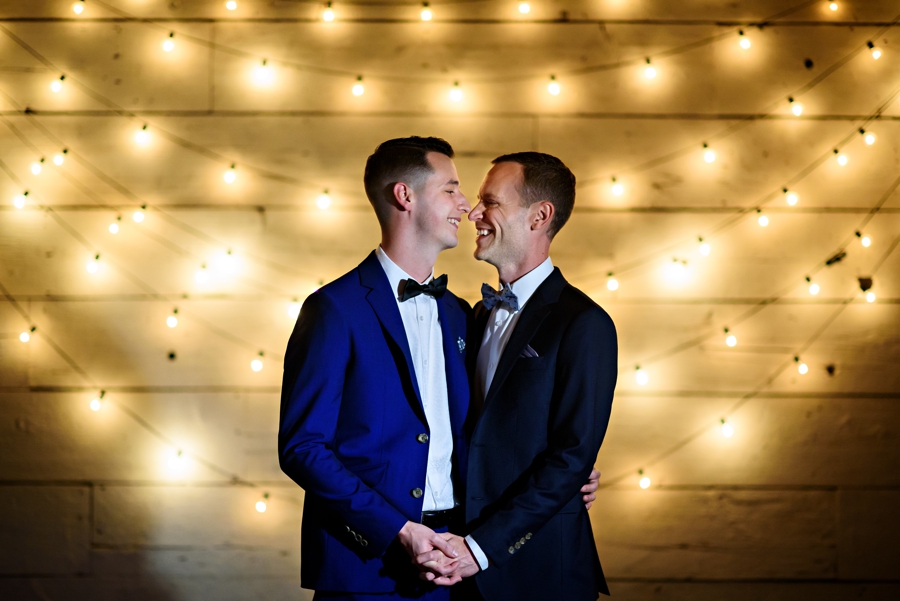 Two grooms laugh and hug after their wedding ceremony at Terrain at Styers in Glen Mills, PA.