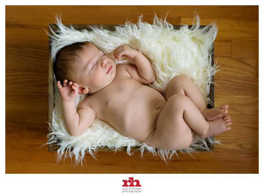 A Newborn Baby sleeps in a rustic box on fur in Philadelphia Newborn Photography Session.