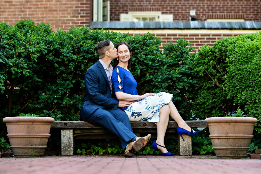 A stylish couple sitting on a bench in Philadelphia during their engagement session.