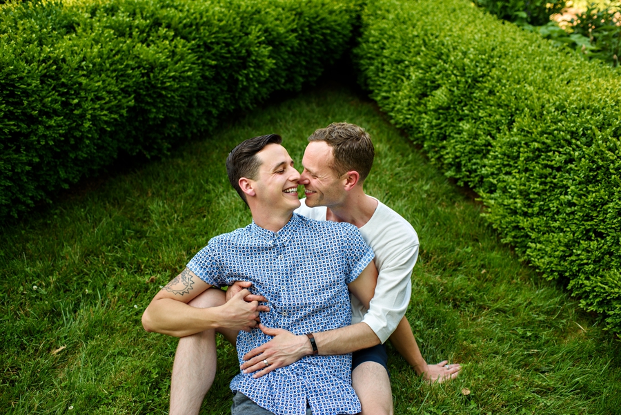 A gay couple snuggle in the grass during their Same-Sex Engagement Session in Princeton, NJ.