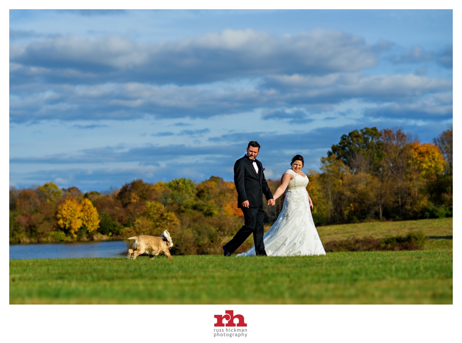 A couple walk with their dog on their wedding day in Princeton, NJ.