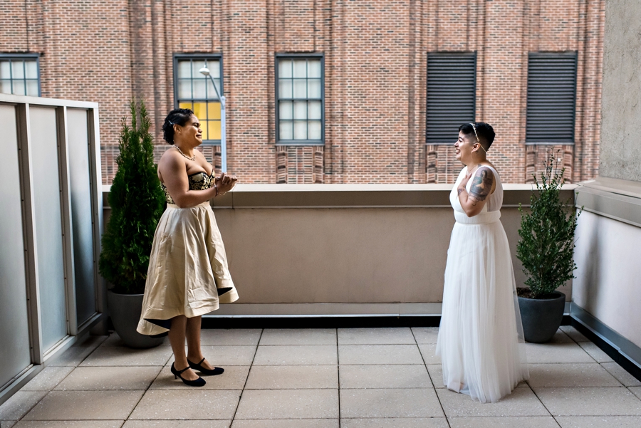 Two brides see each other for the first time before the wedding ceremony during their first look.