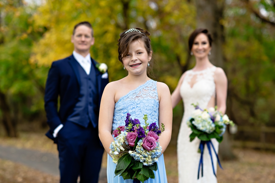 A newly married couple with their daughter as her something blue.